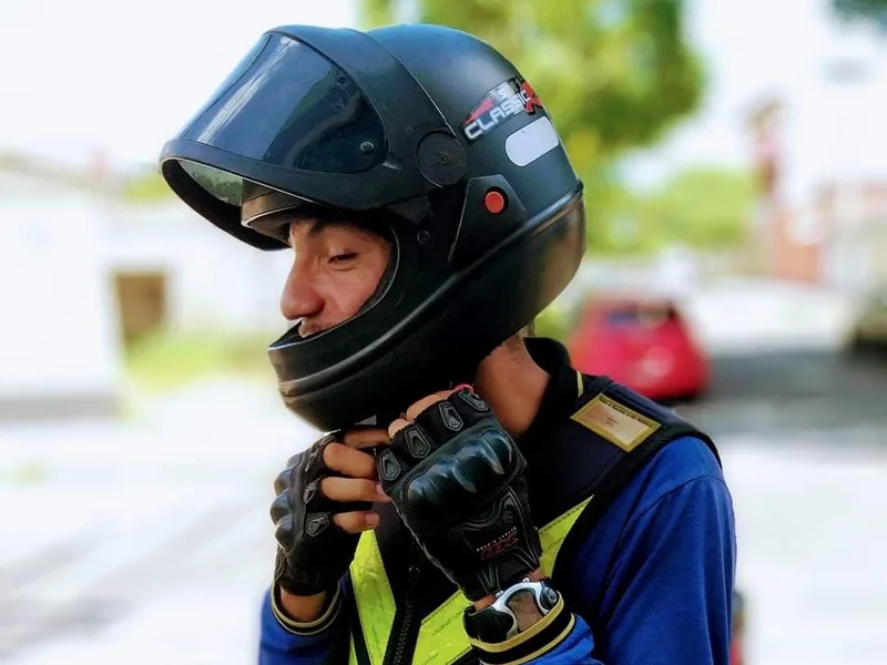 Motoboy ajustando o capacete antes de uma entrega